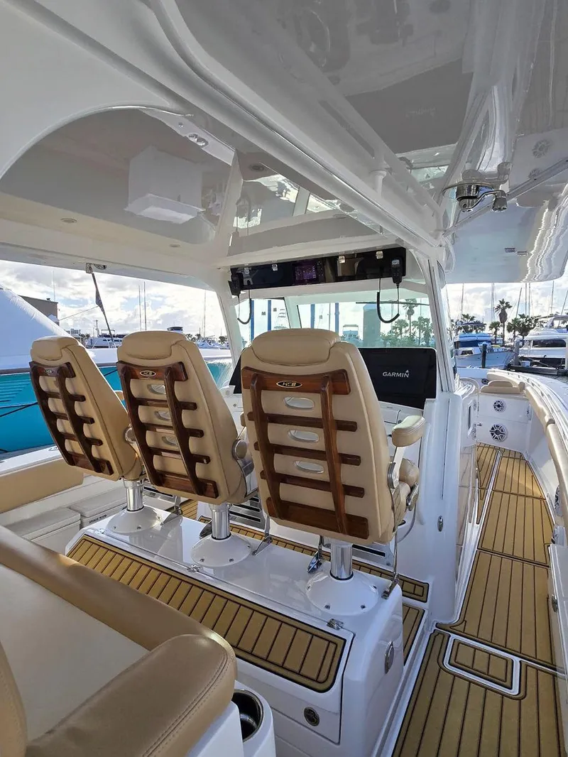 Slide: The Image of 2023 HCB Suenos boat dashboard with rod holders and Garmin electronics at a marina. - 17