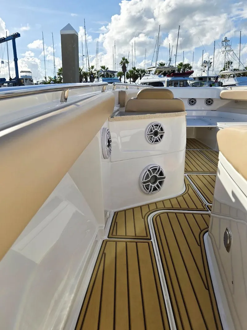 Slide: The Image of 2023 HCB Suenos boat interior with cushioned seating and teak-style flooring. - 36