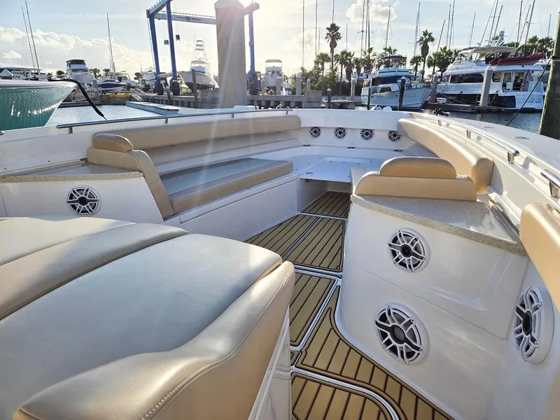 Slide: The Image of 2023 HCB Suenos boat interior with beige seating, docked under bright sunlight. - 42