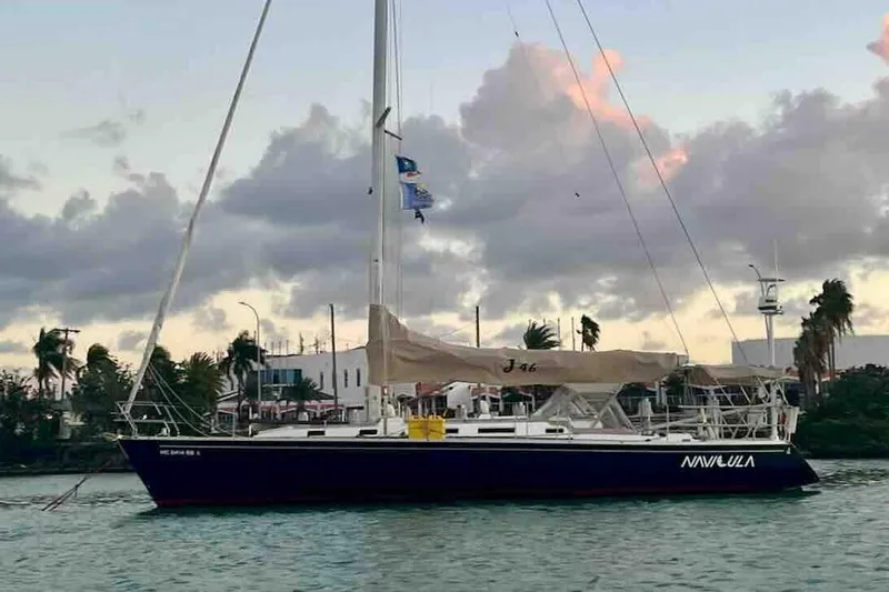 Slide: The Image of 2001 J Boats J/46 sailboat docked at sunset with cloudy sky backdrop. - 0