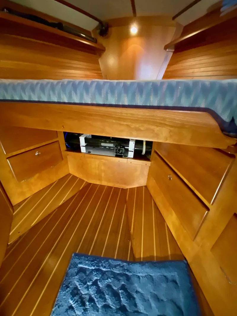Slide: The Image of Interior cabin of 2001 J Boats J/46 with wooden finish and blue bedding. - 10