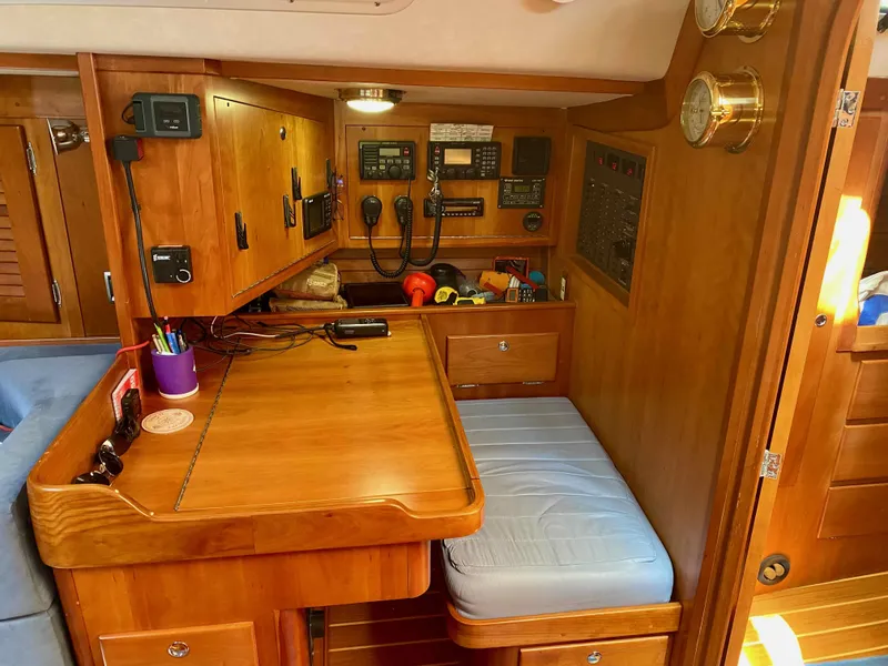 Slide: The Image of Navigation station inside 2001 J Boats J/46, featuring wooden cabinetry and communication equipment. - 14