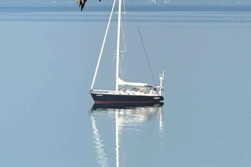 Slide: The Image of Sailboat J/46 by J Boats, 2001 model, on calm water reflecting its image. - 2