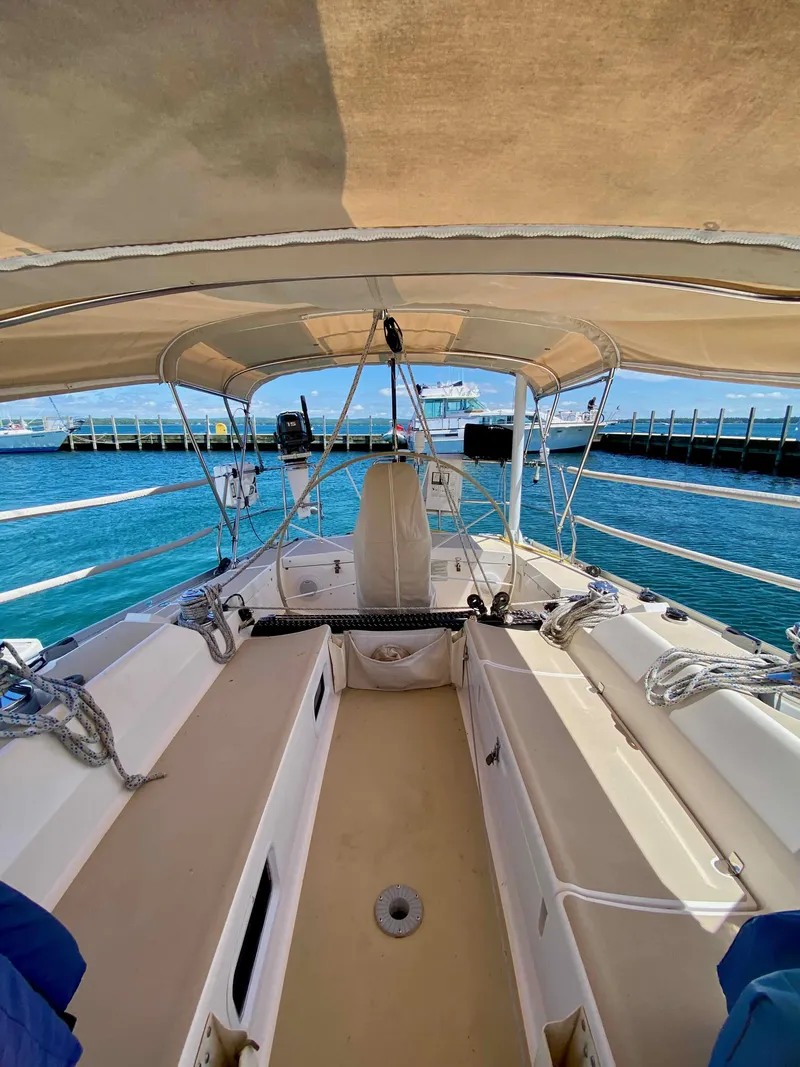 Slide: The Image of 2001 J Boats J/46 sailboat cockpit with canopy, docked by clear blue water. - 20