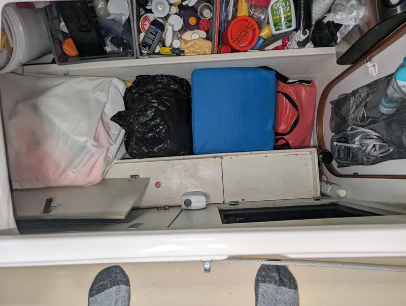 Slide: The Image of Storage compartment in a 2001 J Boats J/46, filled with various items and supplies. - 47