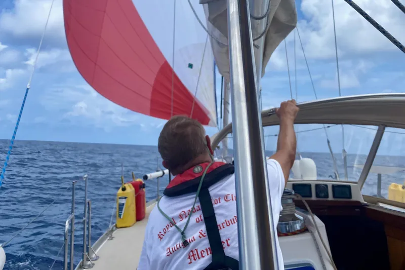 Slide: The Image of Man sailing a 2001 J Boats J/46 with red spinnaker on open ocean. - 7