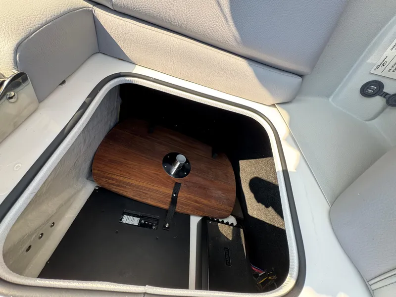 Slide: The Image of Storage compartment in 2025 Regal LS9 Surf boat with wooden panel and equipment. - 14
