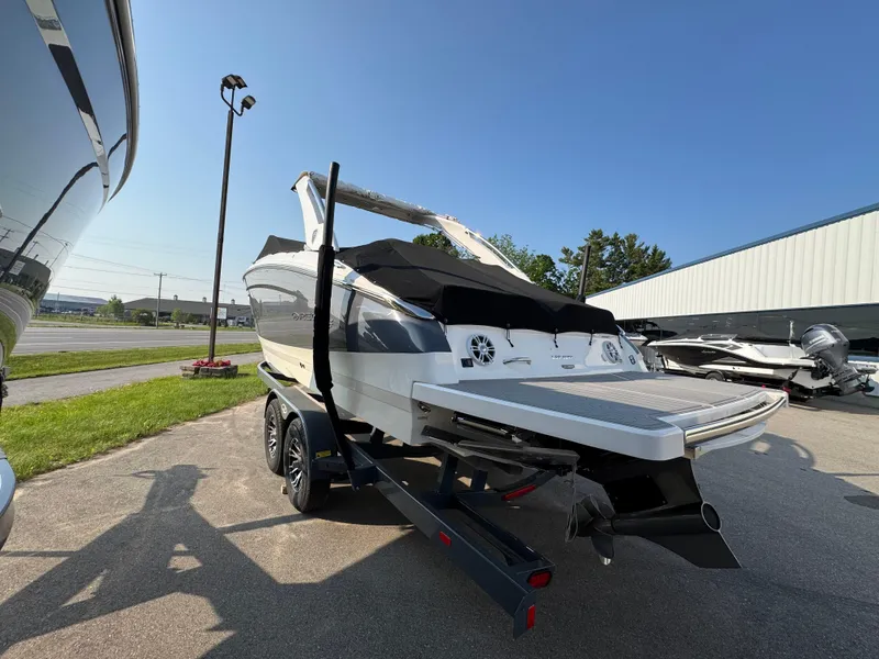 Slide: The Image of 2025 Regal LS9 Surf boat on trailer, parked outdoors under clear sky. - 2