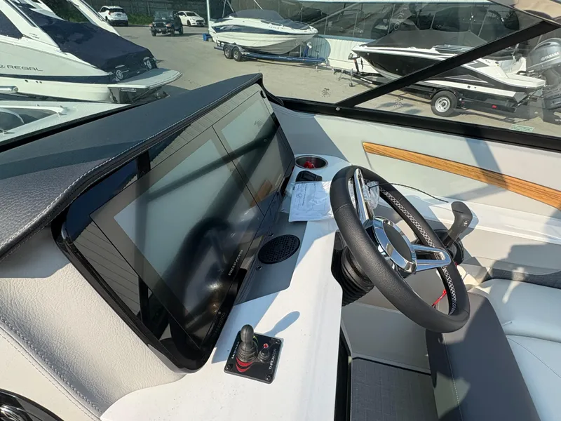 Slide: The Image of 2025 Regal LS9 Surf boat dashboard with steering wheel and touchscreen display. - 22