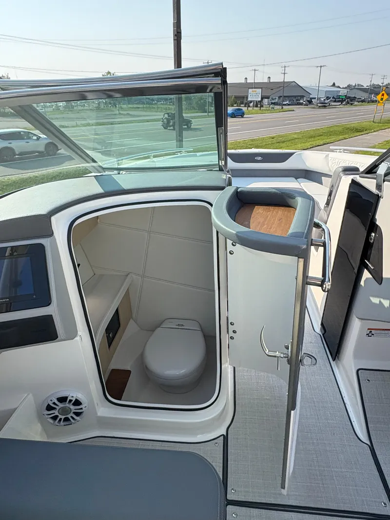Slide: The Image of 2025 Regal LS9 Surf boat interior with open bathroom door, showcasing modern amenities. - 26