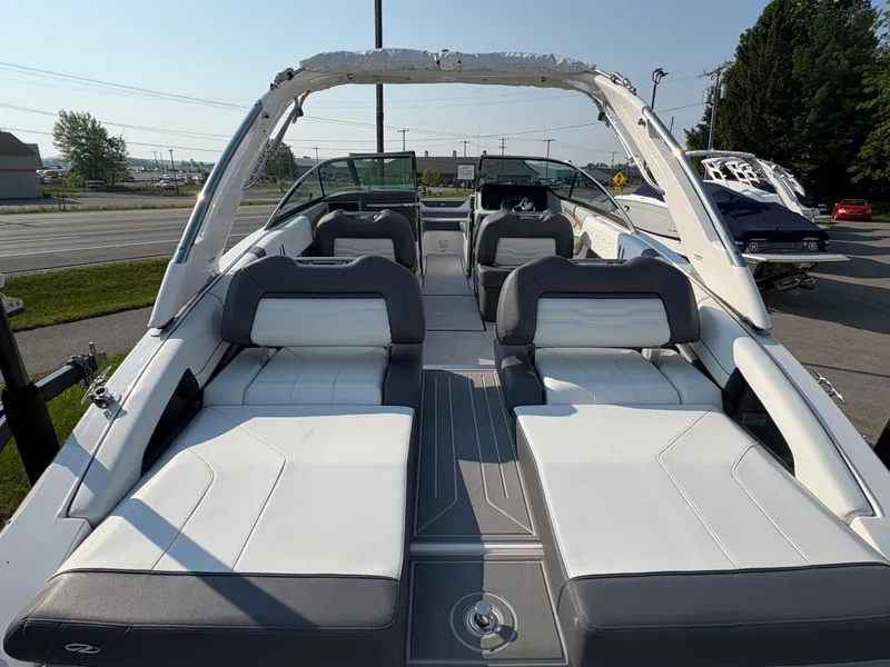 Slide: The Image of 2025 Regal LS9 Surf boat with sleek white and gray seating, docked outdoors. - 36