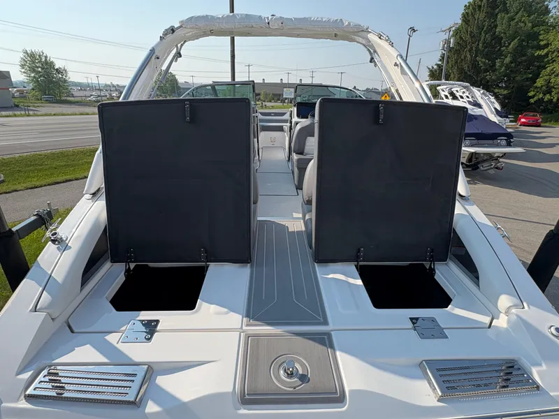 Slide: The Image of 2025 Regal LS9 Surf boat with open storage compartments, docked outdoors. - 37