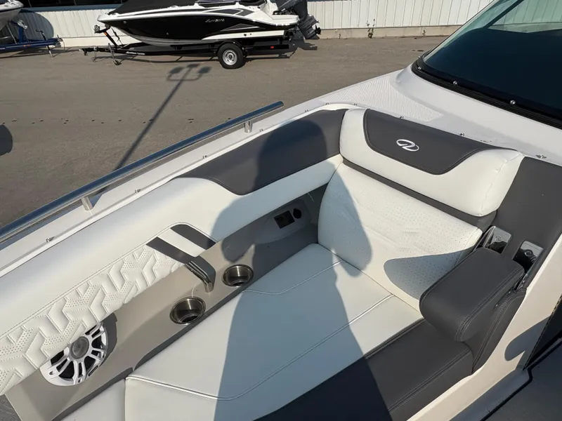 Slide: The Image of 2025 Regal LS9 Surf boat interior with white and gray seating, cup holders, and speaker. - 9