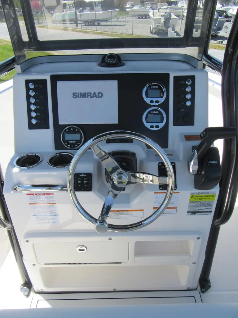 Slide: The Image of 2025 Robalo R180 Center Console dashboard with steering wheel and Simrad display. - 11