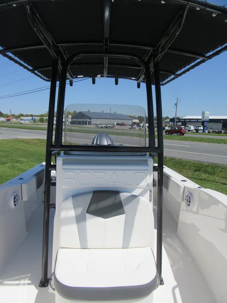 Slide: The Image of 2025 Robalo R180 Center Console boat with T-top, parked outdoors. - 7