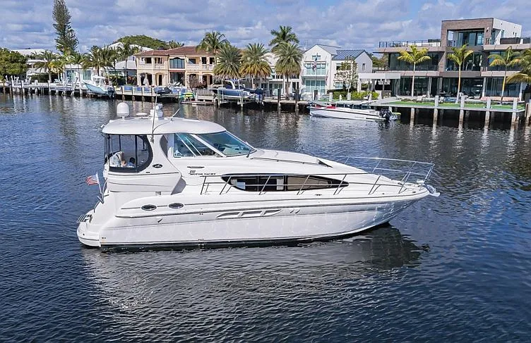 Slide: The Image of 2005 Sea Ray 390 Motor Yacht cruising on a scenic waterfront with luxury homes. - 1