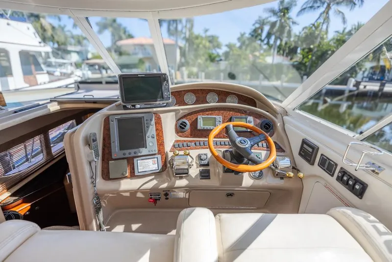 Slide: The Image of 2005 Sea Ray 390 Motor Yacht helm with modern navigation equipment and luxurious steering wheel. - 13