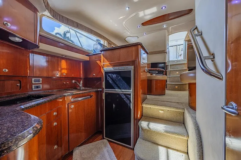 Slide: The Image of Luxurious 2005 Sea Ray 390 Motor Yacht interior with elegant wood cabinetry and modern amenities. - 17