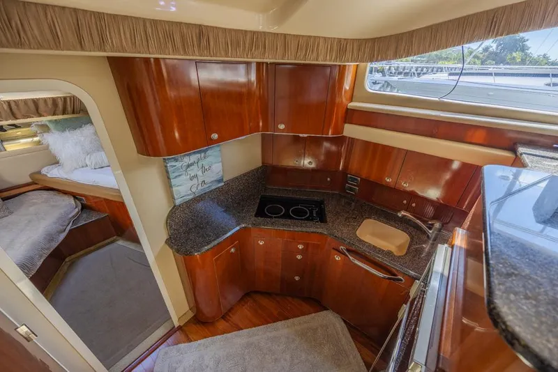 Slide: The Image of 2005 Sea Ray 390 Motor Yacht kitchen with wood cabinetry and modern appliances. - 18