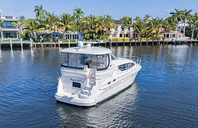 Slide: The Image of 2005 Sea Ray 390 Motor Yacht cruising on a scenic waterway with palm trees. - 2