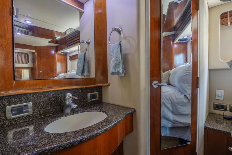 Slide: The Image of 2005 Sea Ray 390 Motor Yacht bathroom with granite countertop and wooden cabinetry. - 22