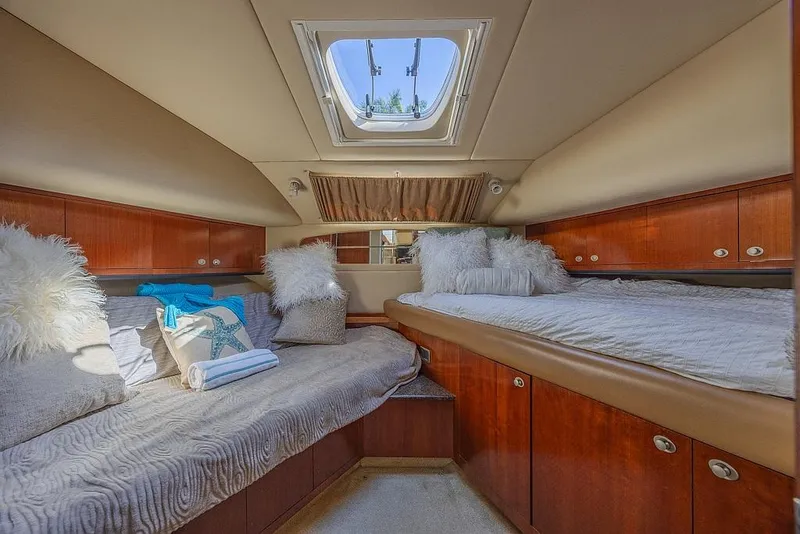 Slide: The Image of Luxurious 2005 Sea Ray 390 Motor Yacht cabin with plush bedding and elegant wood finishes. - 23