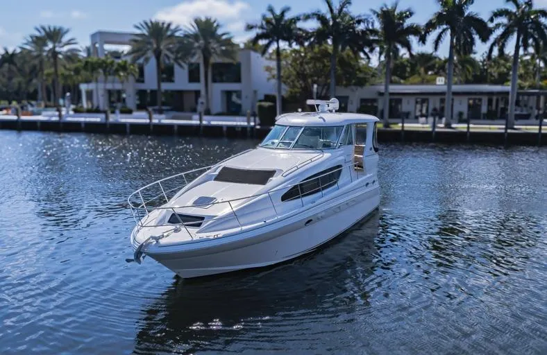 Slide: The Image of 2005 Sea Ray 390 Motor Yacht on a serene waterway with palm trees in the background. - 6
