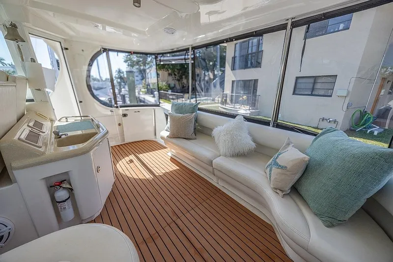 Slide: The Image of 2005 Sea Ray 390 Motor Yacht interior with plush seating and elegant wood flooring. - 8