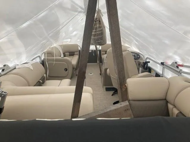Slide: The Image of 2023 Sun Tracker PB 22 RF pontoon boat interior with beige seating under protective cover. - 11