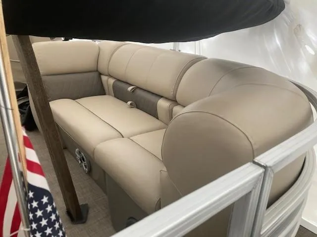 Slide: The Image of 2023 Sun Tracker PB 22 RF boat interior with beige seating and American flag. - 12