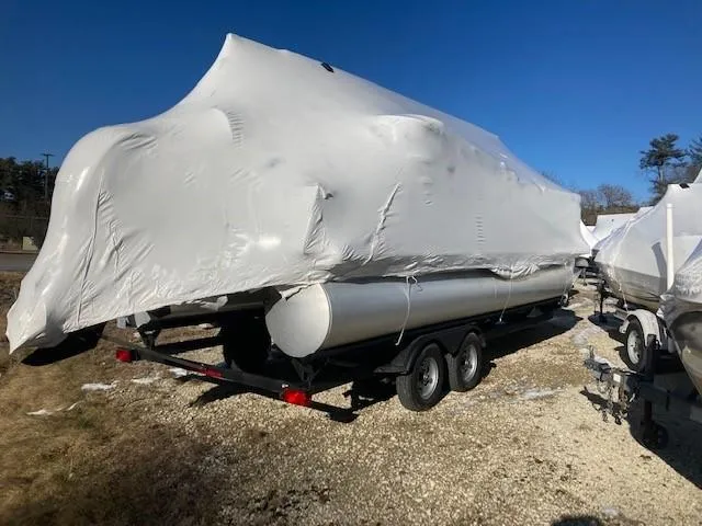 Slide: The Image of 2023 Sun Tracker PB 22 RF pontoon boat covered in protective wrap on trailer. - 3