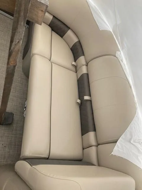 Slide: The Image of 2023 Sun Tracker PB 22 RF boat interior with beige and brown seating. - 7
