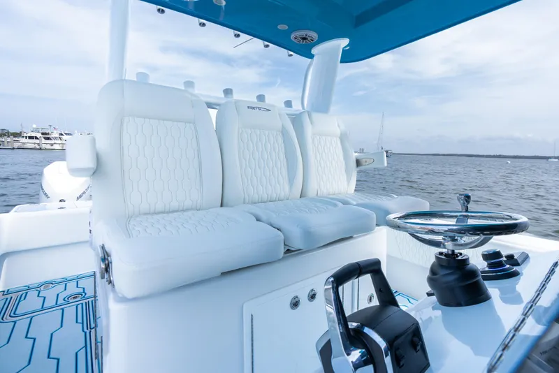 Slide: The Image of 2025 Insetta 35IFC boat interior with white seating and steering wheel, on calm water. - 11