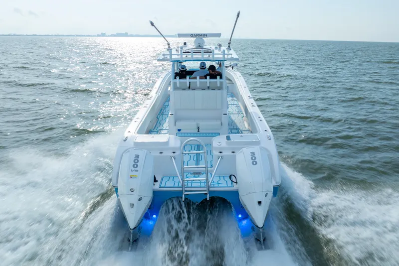 Slide: The Image of 2025 Insetta 35IFC boat cruising on open water, rear view with dual engines. - 4