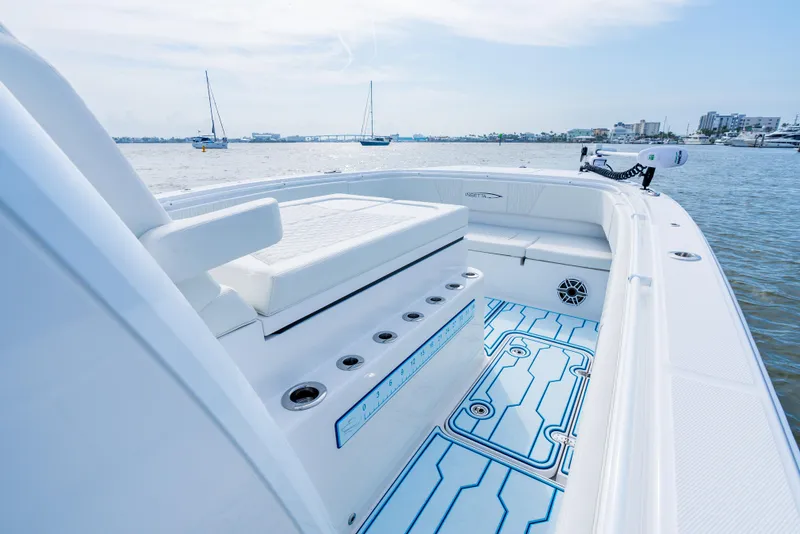 Slide: The Image of 2025 Insetta 35IFC boat interior with seating, rod holders, and blue deck design on calm water. - 8