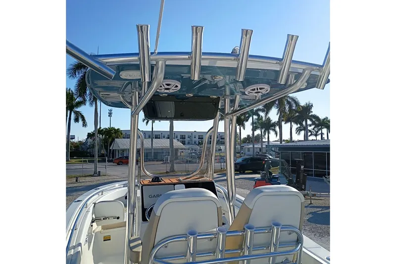 Slide: The Image of 2026 Bulls Bay 255 Center Console boat with T-top and rod holders, parked outdoors. - 10