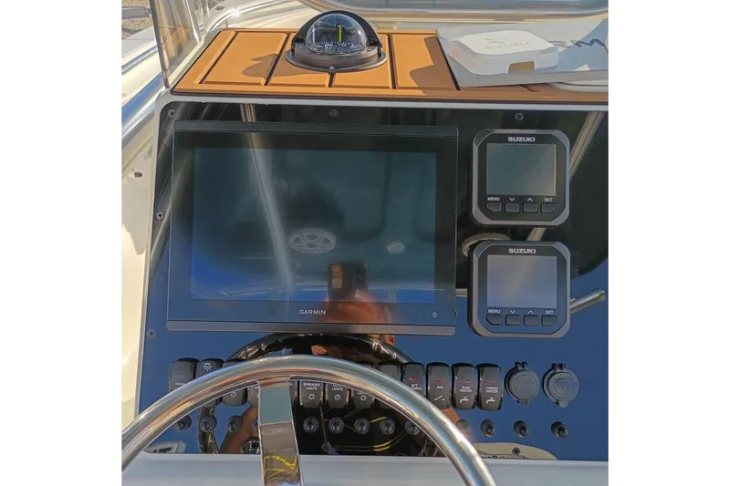 Slide: The Image of 2026 Bulls Bay 255 Center Console dashboard with Garmin and Suzuki displays. - 13