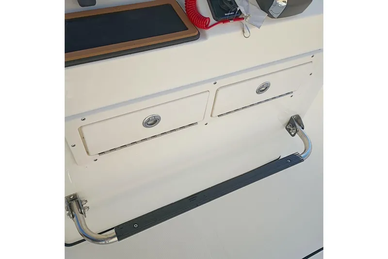 Slide: The Image of 2026 Bulls Bay 255 Center Console boat interior with storage compartments and safety handle. - 21