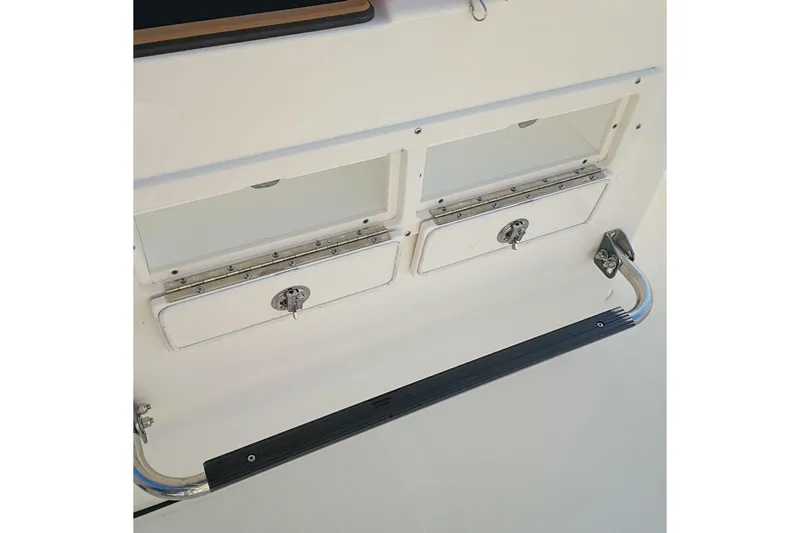 Slide: The Image of 2026 Bulls Bay 255 Center Console storage compartments with secure latches and footrest. - 23