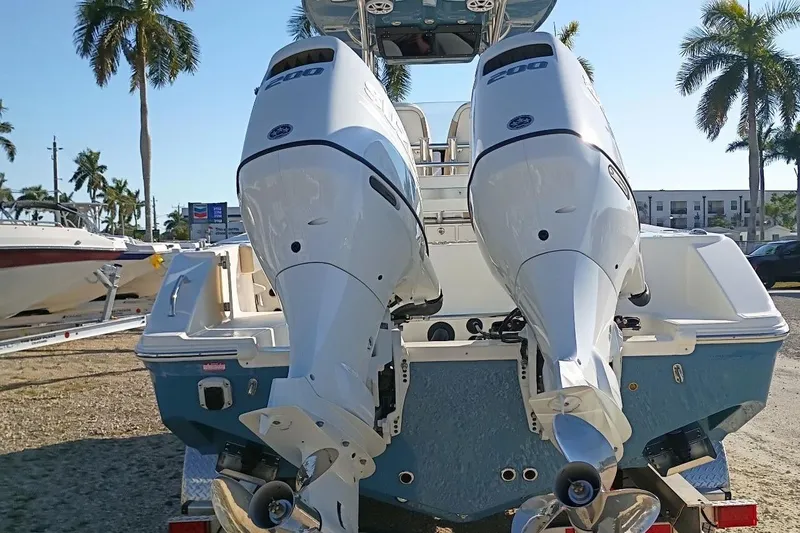 Slide: The Image of 2026 Bulls Bay 255 Center Console boat with dual outboard engines, parked outdoors. - 46