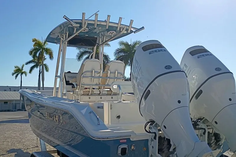 Slide: The Image of 2026 Bulls Bay 255 Center Console boat with dual engines, parked under palm trees. - 48