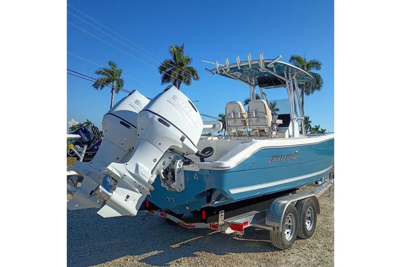 Slide: The Image of 2026 Bulls Bay 255 Center Console boat with dual engines on a trailer, palm trees in background. - 5