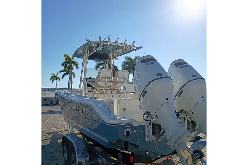 Slide: The Image of 2026 Bulls Bay 255 Center Console boat with dual engines, parked under a sunny sky. - 7