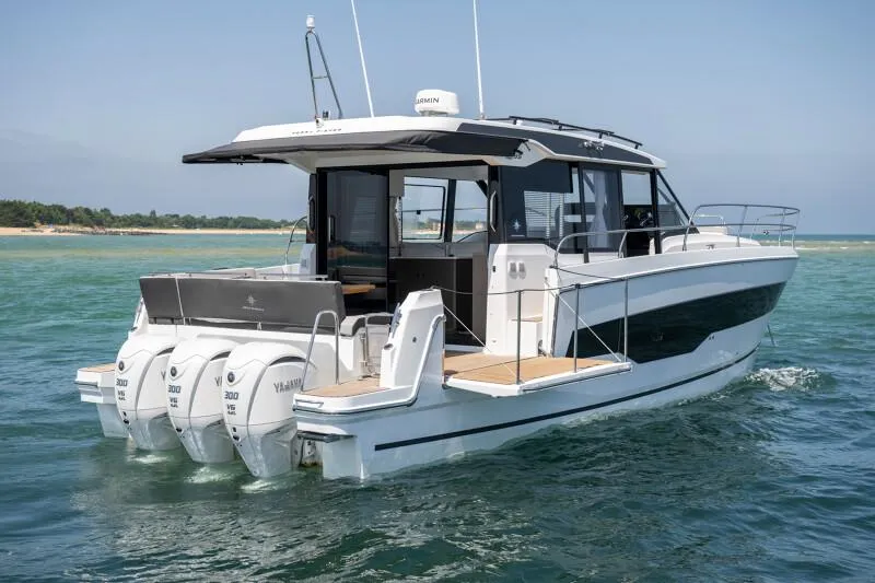 Slide: The Image of 2025 Jeanneau NC 1295 Coupe boat on water, featuring triple Yamaha engines. - 3