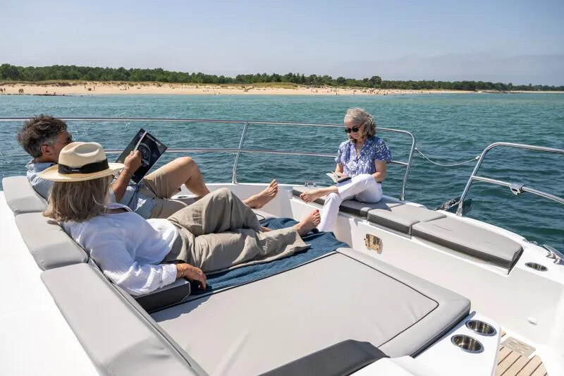 Slide: The Image of People relaxing on a 2025 Jeanneau NC 1295 Coupe yacht, enjoying the sunny sea view. - 6