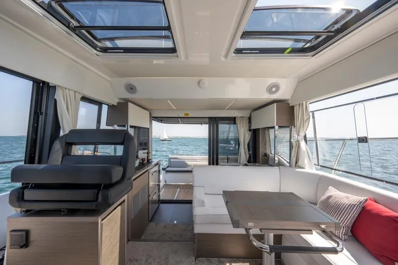Slide: The Image of Interior of 2025 Jeanneau NC 1295 Coupe yacht with modern seating and ocean view. - 9