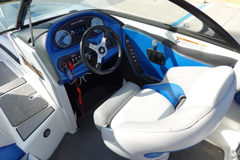 Slide: The Image of 2013 Centurion Enzo SV230 Plus boat interior with blue and white seating and dashboard. - 10