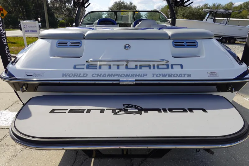 Slide: The Image of 2013 Centurion Enzo SV230 Plus boat, rear view, showcasing branding and swim platform. - 5