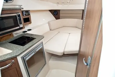 Slide: The Image of 2025 Boston Whaler 285 Conquest cabin interior with kitchenette and seating area. - 10