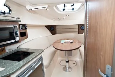 Slide: The Image of 2025 Boston Whaler 285 Conquest cabin interior with kitchenette and seating area. - 12